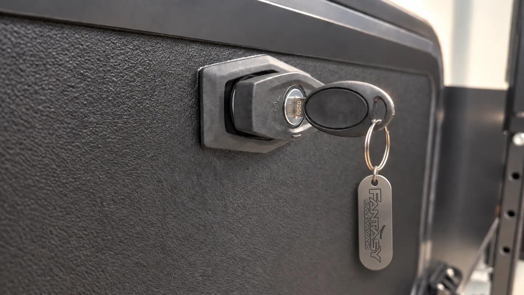 Key with a Fantasy Caravan fob turned in an external hatch lock