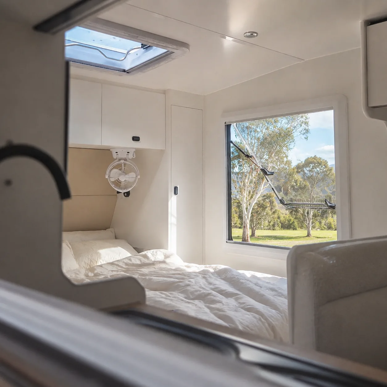 Skyline caravan bedroom lit by a roof hatch and side window, with the bed made up