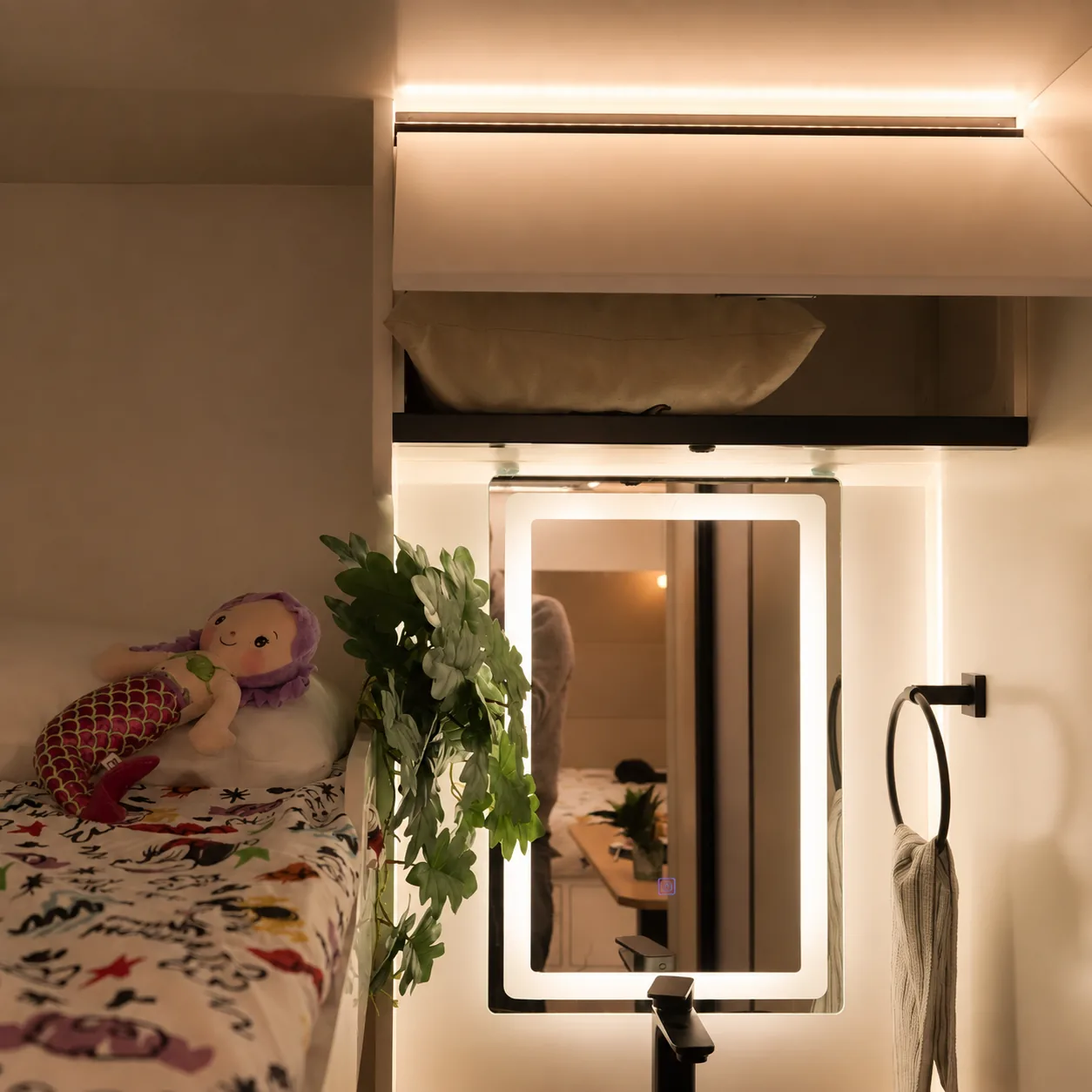 Bunk area with a backlit mirror and soft night lighting