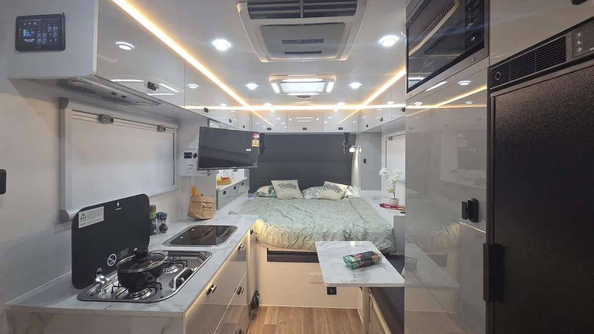 Hard top interior with overhead cabinets all round and a tall fridge