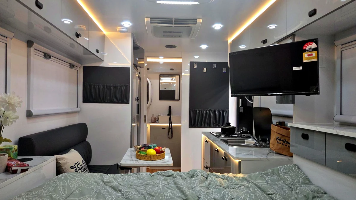 Hybrid caravan interior with TV, bed and storage