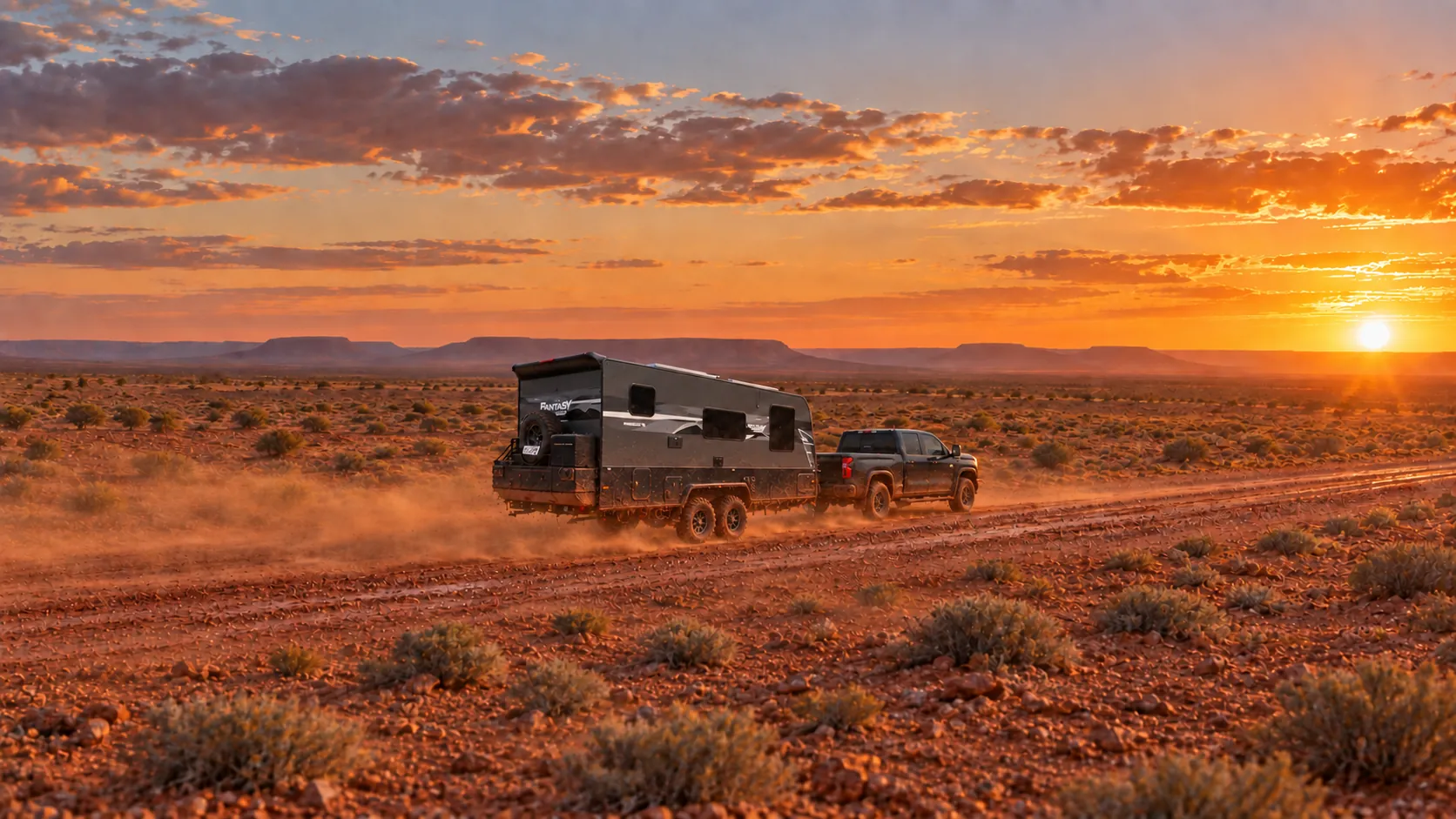 Horizon caravan being towed along a red-dirt outback track at sunset