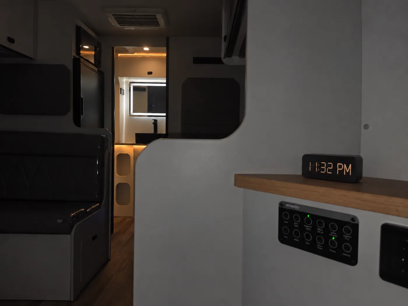 View from the bedside controls towards the illuminated bathroom through a dark cabin