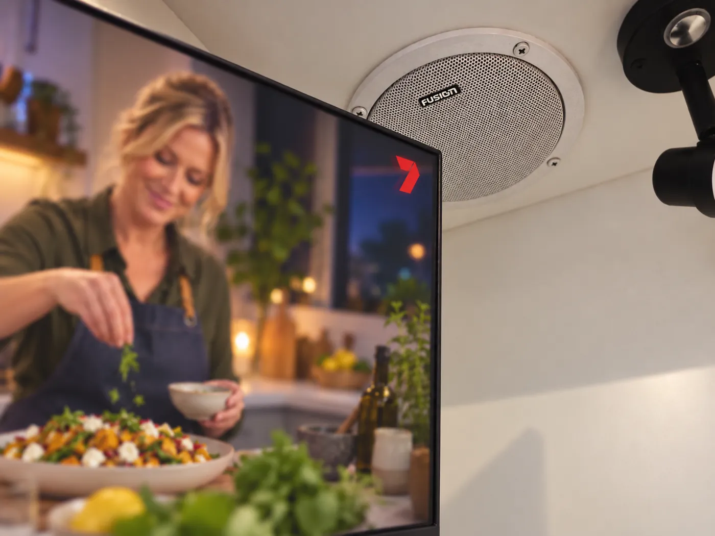 Wall-mounted Smart TV beside a ceiling speaker inside a Horizon caravan