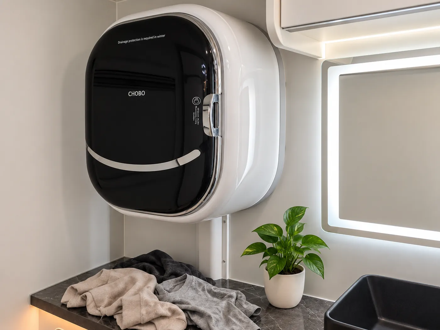 Horizon wall-mounted washing machine with laundry and a small plant beside the basin